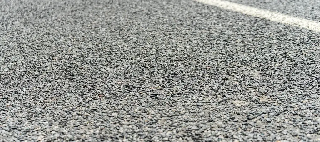 A clean, newly paved commercial parking lot displaying pristine asphalt and professional concrete curb installations.